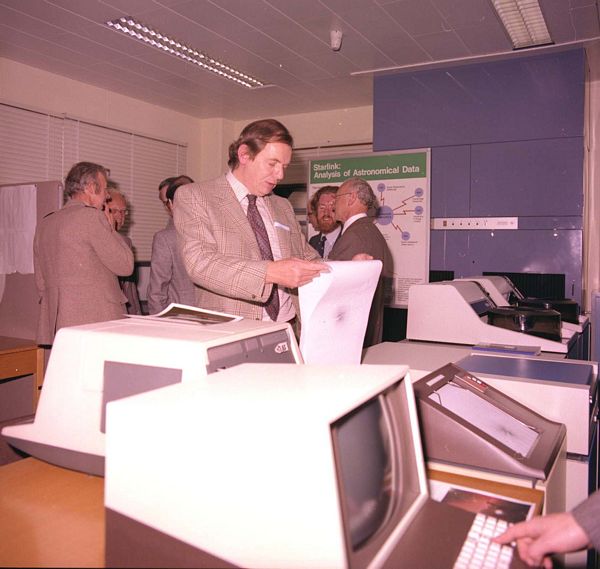 Mike Disney views some Versatek output. Bob Dickens on the left at the back